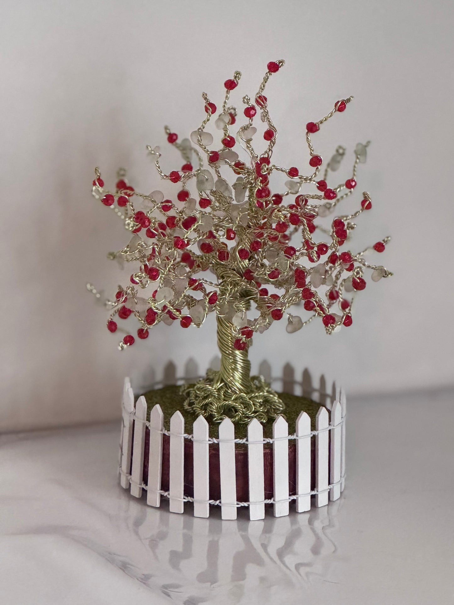 Sea glass tree with mini picket fence. Green wire with White Sea glass and red crystal beads and LED Lights
